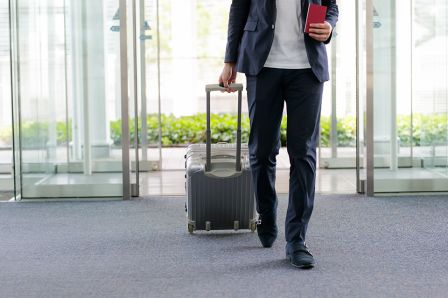 Foto: Mann mit Koffer am Flughafen